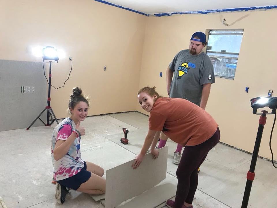 Teens hanging drywall in Houston